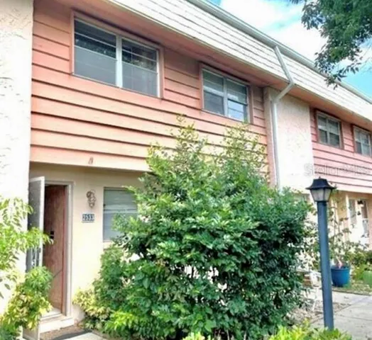 a view of a house with potted plants and a tree