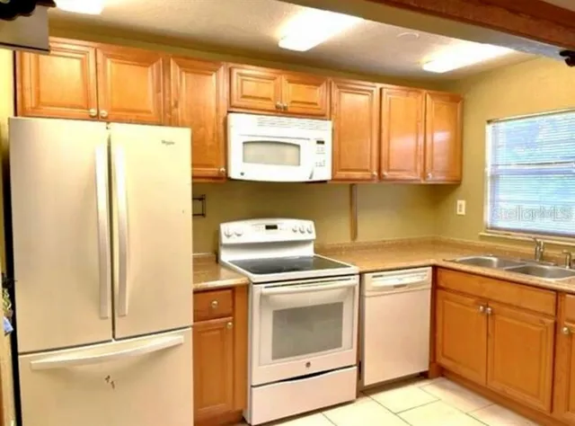 a kitchen with a refrigerator sink and cabinets