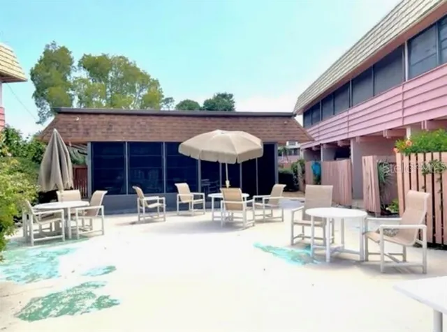 a view of a patio with a table and chairs under an umbrella