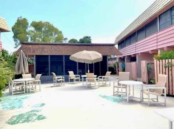 a view of a patio with a table and chairs under an umbrella