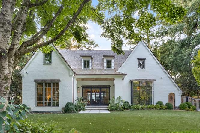 a front view of a house with a garden and plants