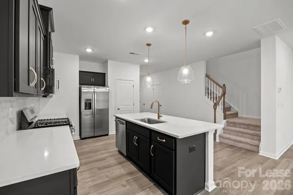 a kitchen with a sink a counter top space stainless steel appliances and cabinets