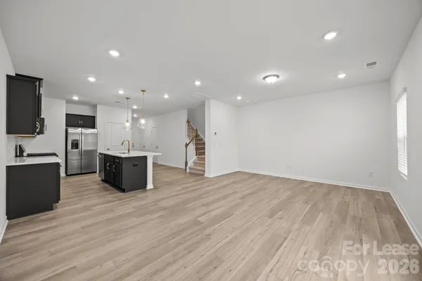 a large kitchen with stainless steel appliances a large counter top and wooden floors