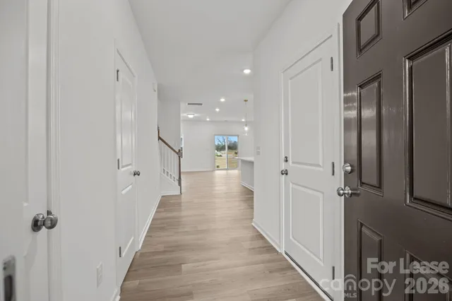 a view of a hallway with wooden floor and staircase