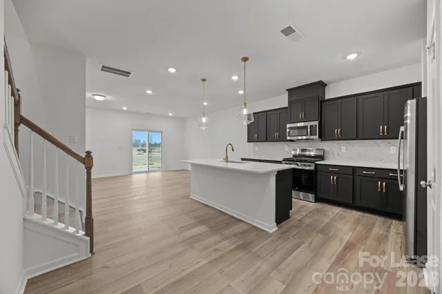 a large kitchen with stainless steel appliances sink a microwave and cabinets