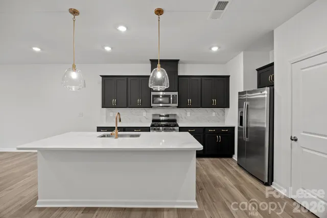 a kitchen with kitchen island a sink stainless steel appliances and cabinets