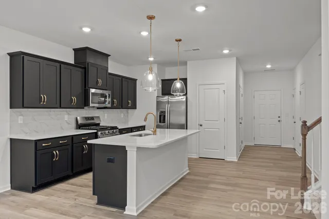a kitchen with a sink a stove a refrigerator and cabinets