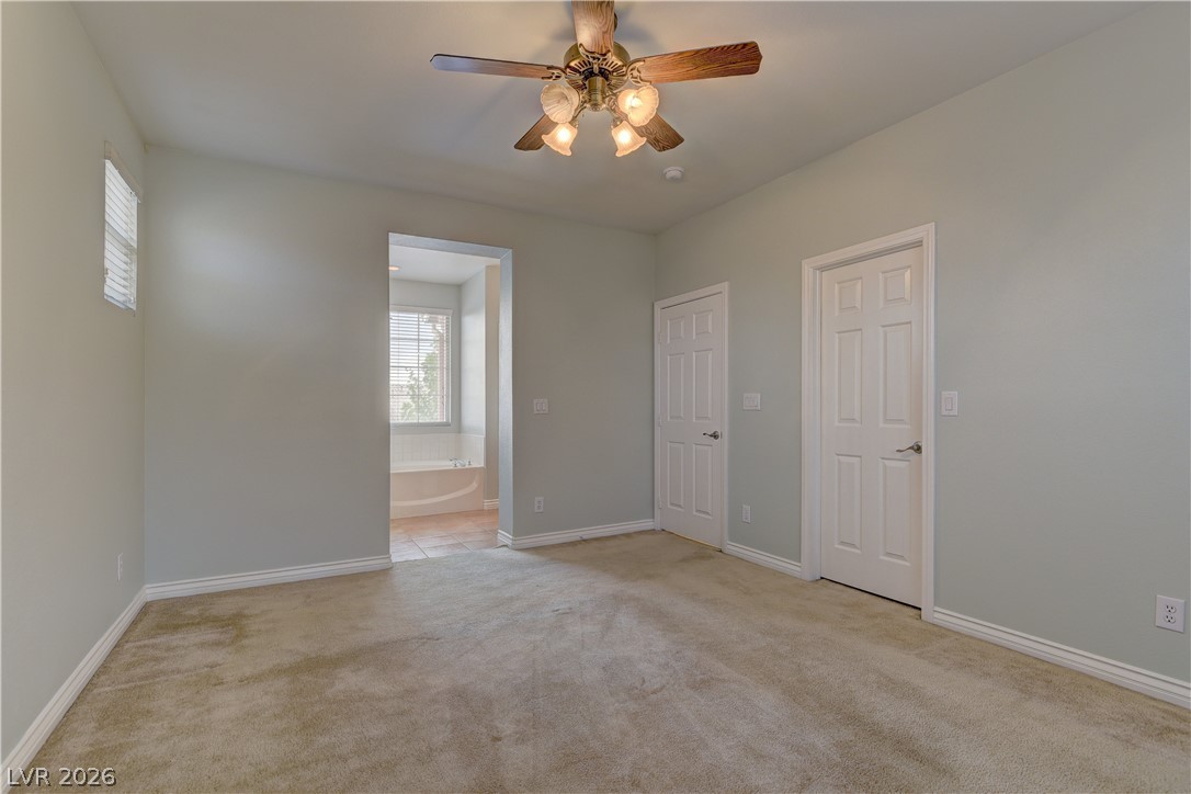 1813 Snow Spring Lane Las Vegas, NV 89134 - Photo 24 of 37 A comfortable bedroom suite, complete with a ceiling fan and direct access to a private bathroom retreat.