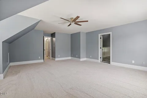 an empty room with windows and ceiling fan view