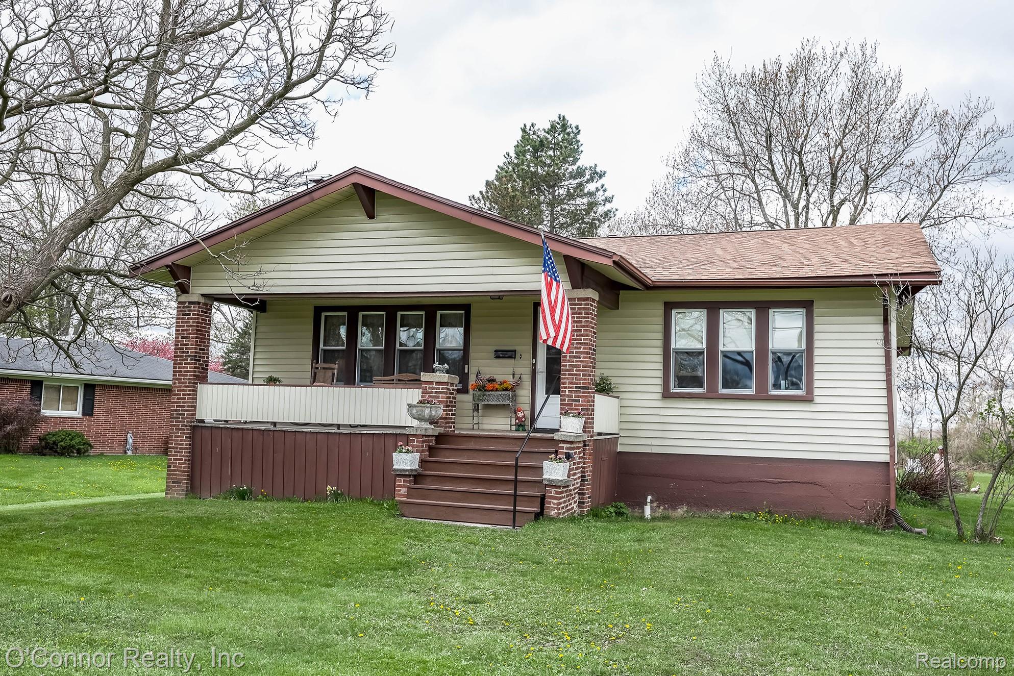 3323 Kinney Road Emmett, MI 48022 - Photo 22 of 29 Craftsman-style home featuring a covered front porch with brick pillars, a gabled roofline, and siding exterior