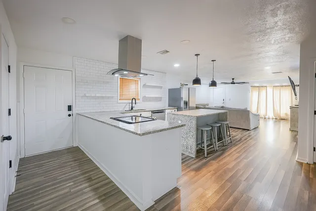 a kitchen with a sink a stove cabinets and wooden floor