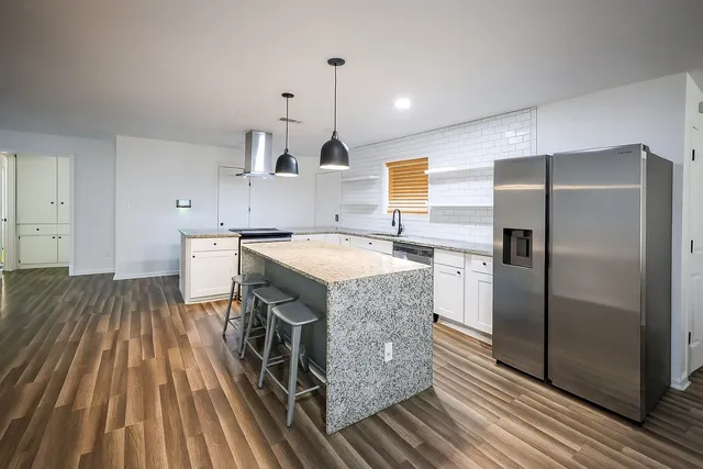 a kitchen with stainless steel appliances granite countertop a sink stove and refrigerator