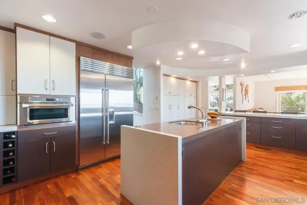 a kitchen with stainless steel appliances granite countertop a refrigerator a sink a stove and a refrigerator