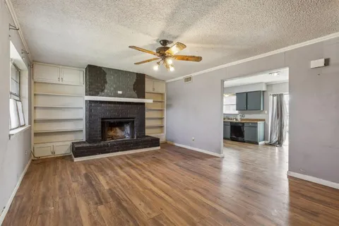 a view of a livingroom with a fireplace a ceiling fan and fireplace