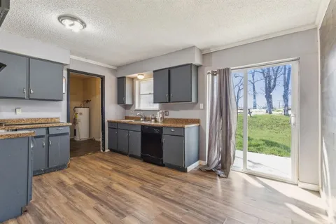 a kitchen with a refrigerator sink and cabinets