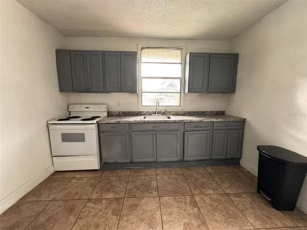a kitchen with a stove sink and cabinets