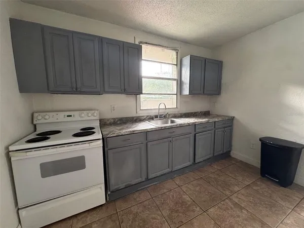 a kitchen with a stove sink and cabinets