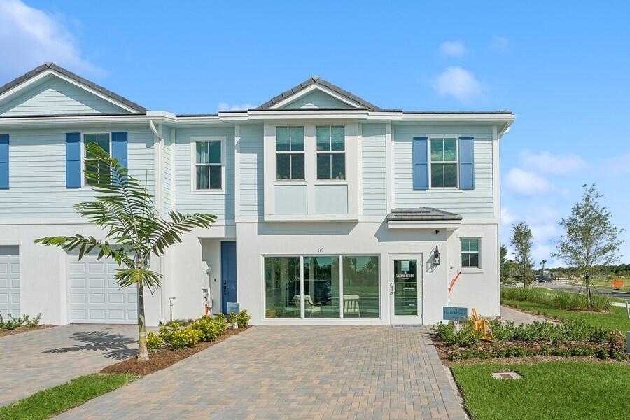 128 Southeast Birch Terrace, Unit 1579 Stuart, FL 34997 - Photo 1 of 44 a front view of a house with a garden and plants