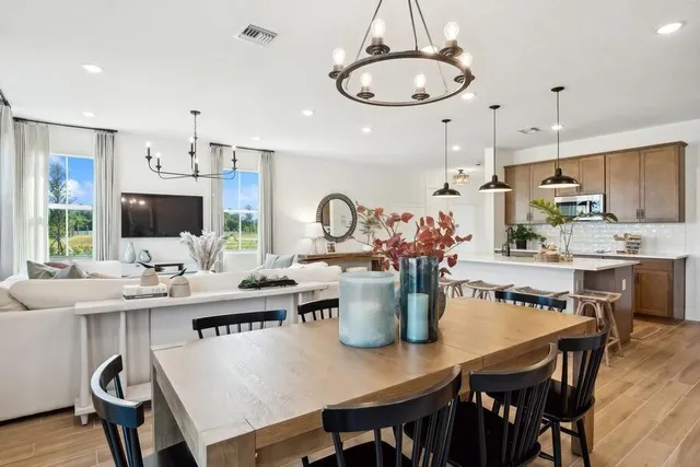 a dining room with stainless steel appliances kitchen island a table and chairs