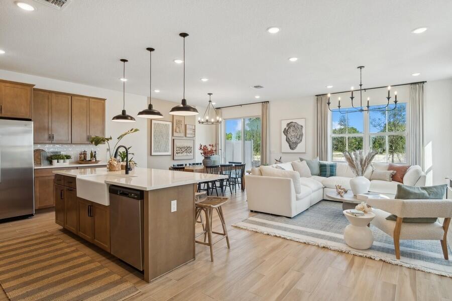 128 Southeast Birch Terrace, Unit 1579 Stuart, FL 34997 - Photo 14 of 44 a large kitchen with stainless steel appliances kitchen island granite countertop a large center island attached withe living room
