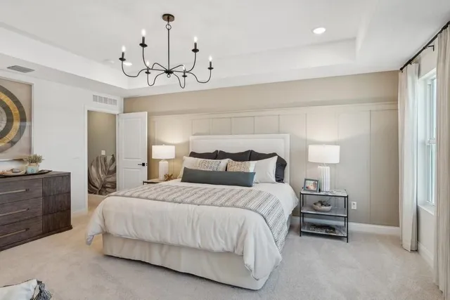 a bedroom with bed and a chandelier