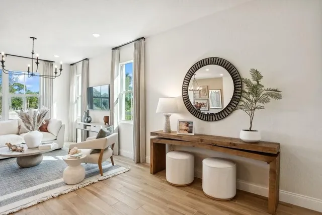 a living room with furniture a mirror a lamp and a large window
