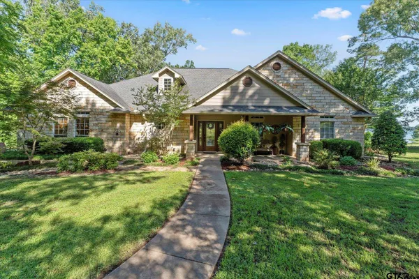 a front view of a house with yard and green space