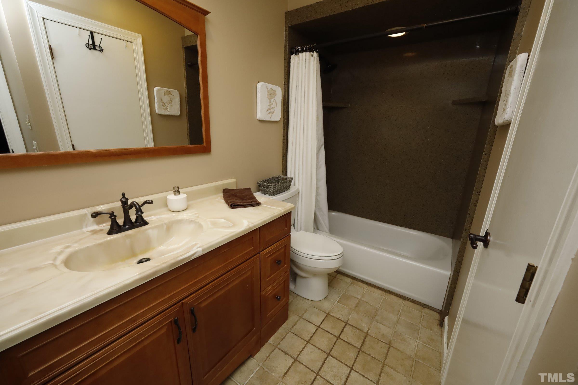 10904 Brass Kettle Road Raleigh, NC 27614 - Photo 32 of 41 a bathroom with a sink a toilet a mirror and shower