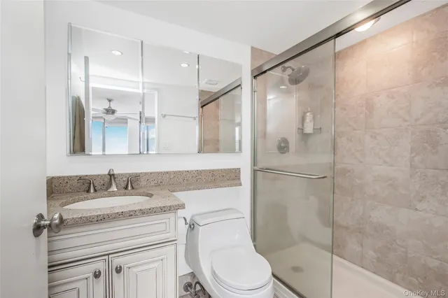 a bathroom with a granite countertop sink toilet and shower