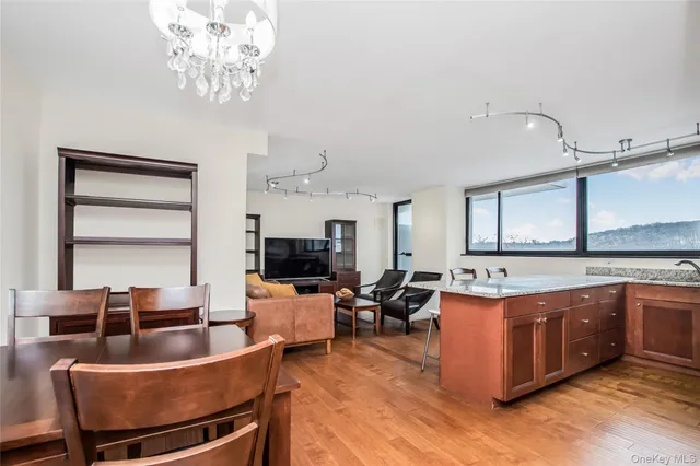 a living room with stainless steel appliances kitchen island granite countertop furniture a large window and a kitchen view