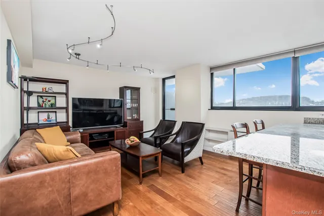 a living room with furniture a flat screen tv and kitchen view