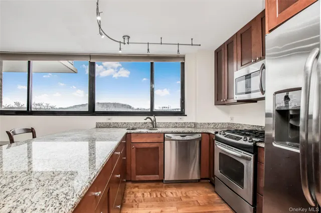 a kitchen with stainless steel appliances granite countertop a sink stove and refrigerator