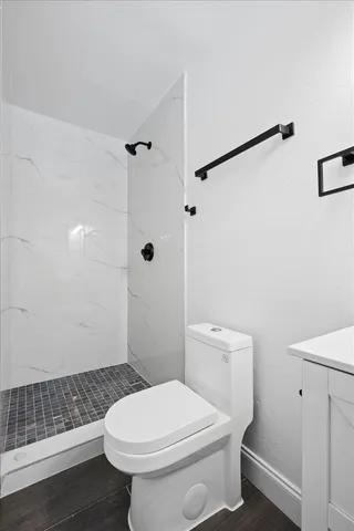 a white toilet sitting next to a bathroom sink and a shower