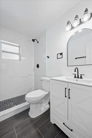 a bathroom with a toilet sink and mirror