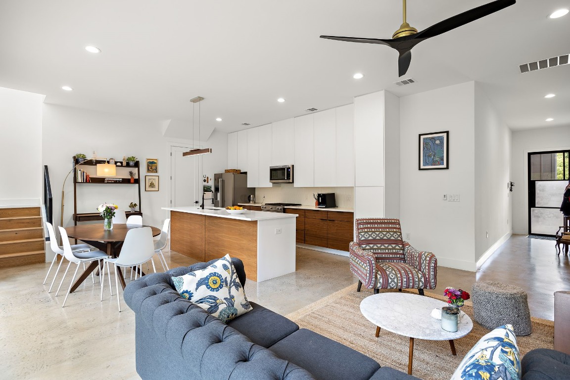 a living room with furniture kitchen view and a dining table