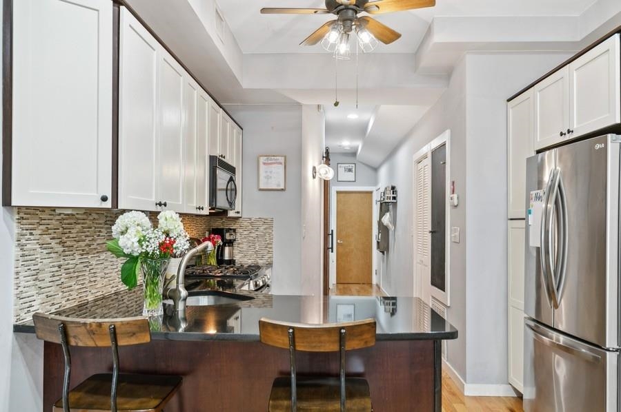 a dining room with furniture cabinetry a chandelier and kitchen view