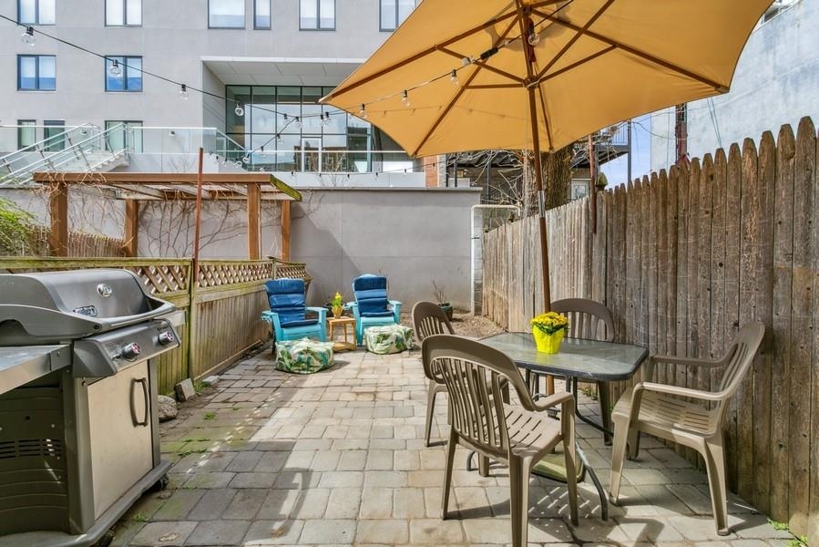412 Monroe Street, Unit 2 Hoboken, NJ 07030 - Photo 4 of 16 a view of a patio with table and chairs under an umbrella