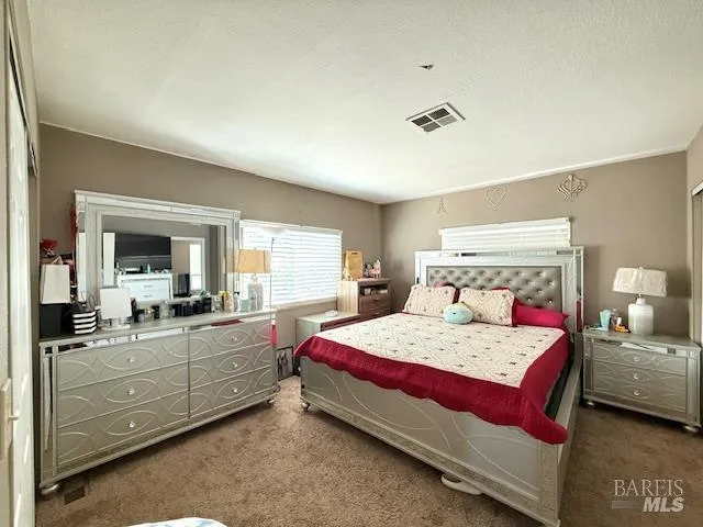 a bedroom with a large bed and a large mirror