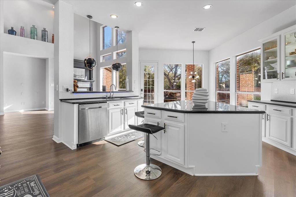 8306 Sawgrass Lane Rowlett, TX 75089 - Photo 11 of 35 a kitchen with stainless steel appliances granite countertop a stove and a sink with wooden floor