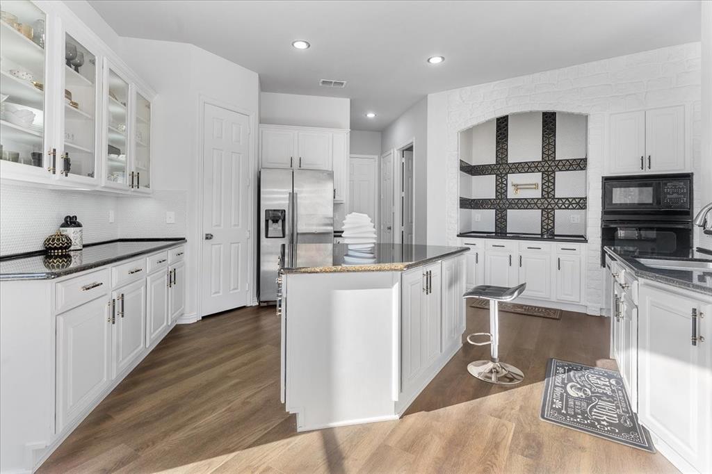 8306 Sawgrass Lane Rowlett, TX 75089 - Photo 12 of 35 a kitchen with stainless steel appliances kitchen island granite countertop a sink stove and refrigerator
