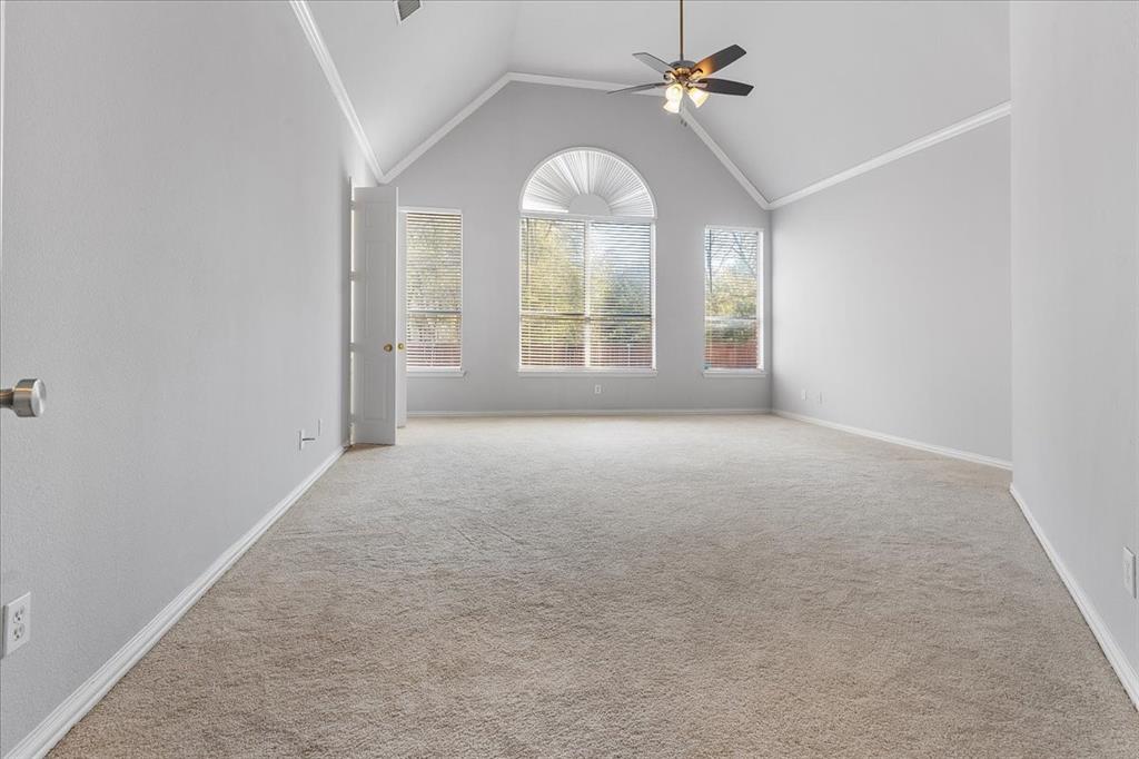 8306 Sawgrass Lane Rowlett, TX 75089 - Photo 17 of 35 an empty room with chandelier fan and windows