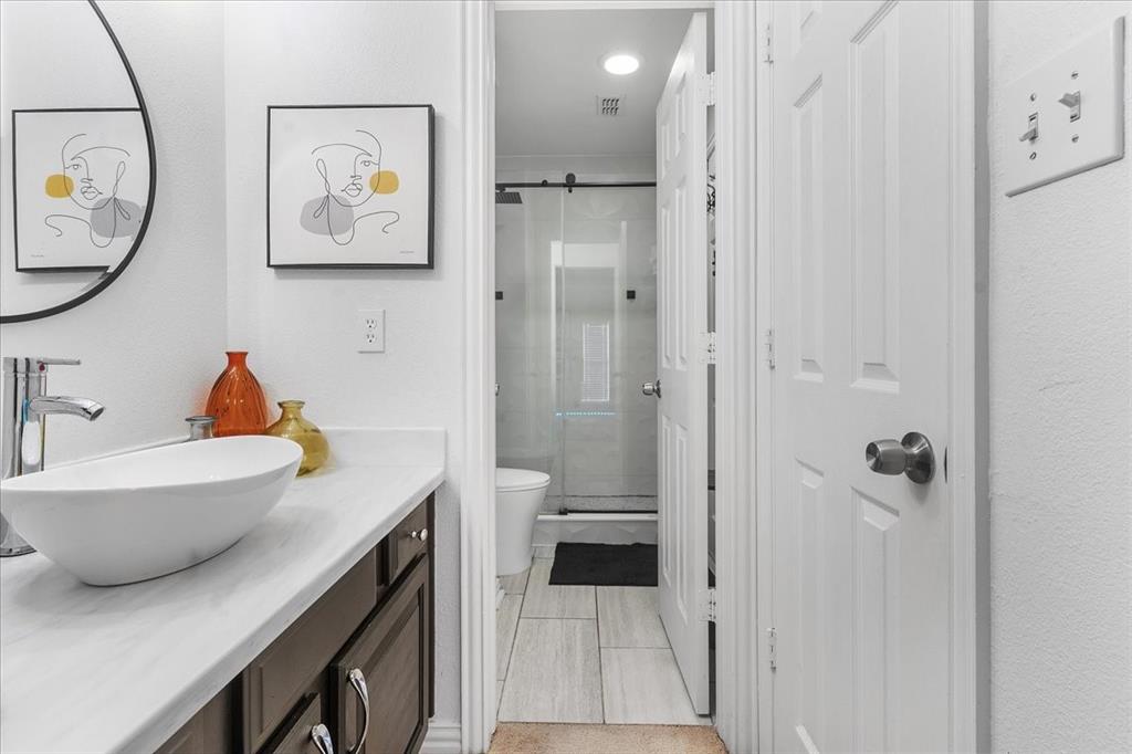 8306 Sawgrass Lane Rowlett, TX 75089 - Photo 21 of 35 a bathroom with a sink a mirror a lamp and bathtub