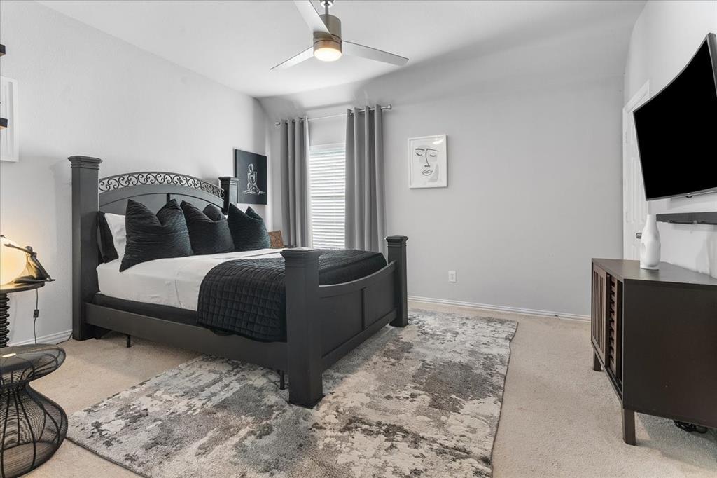 8306 Sawgrass Lane Rowlett, TX 75089 - Photo 23 of 35 a bedroom with a bed and a flat screen tv