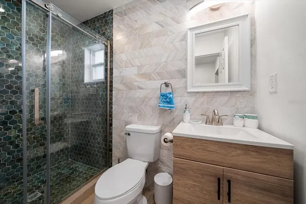 a bathroom with a sink a toilet and shower