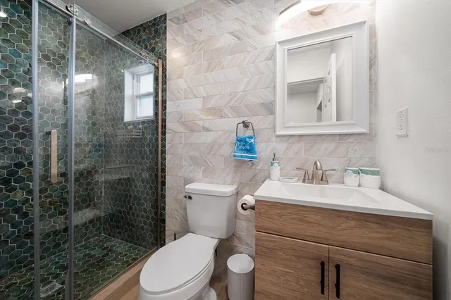 a bathroom with a sink a toilet and shower