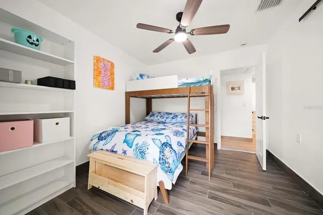 a bedroom with a bed and wooden floor