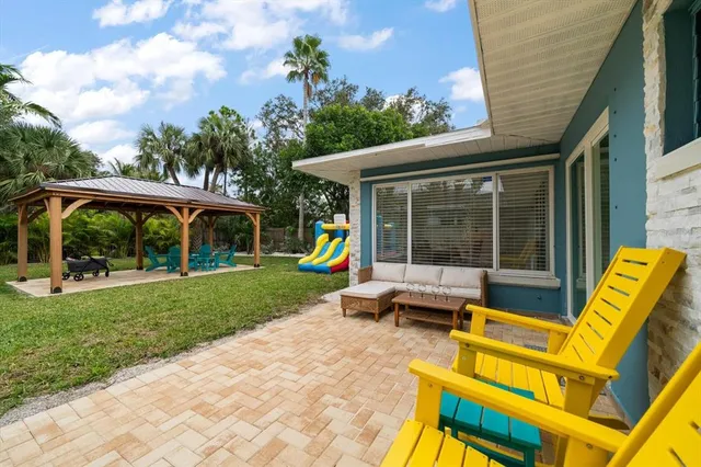 a view of a house with a yard patio and a garden