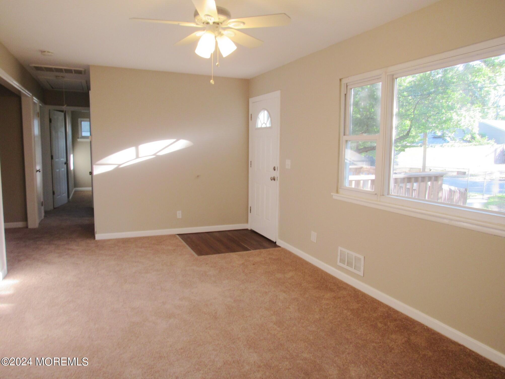 115 Solar Drive Brick, NJ 08724 - Photo 6 of 15 en empty room with windows and chandelier fan