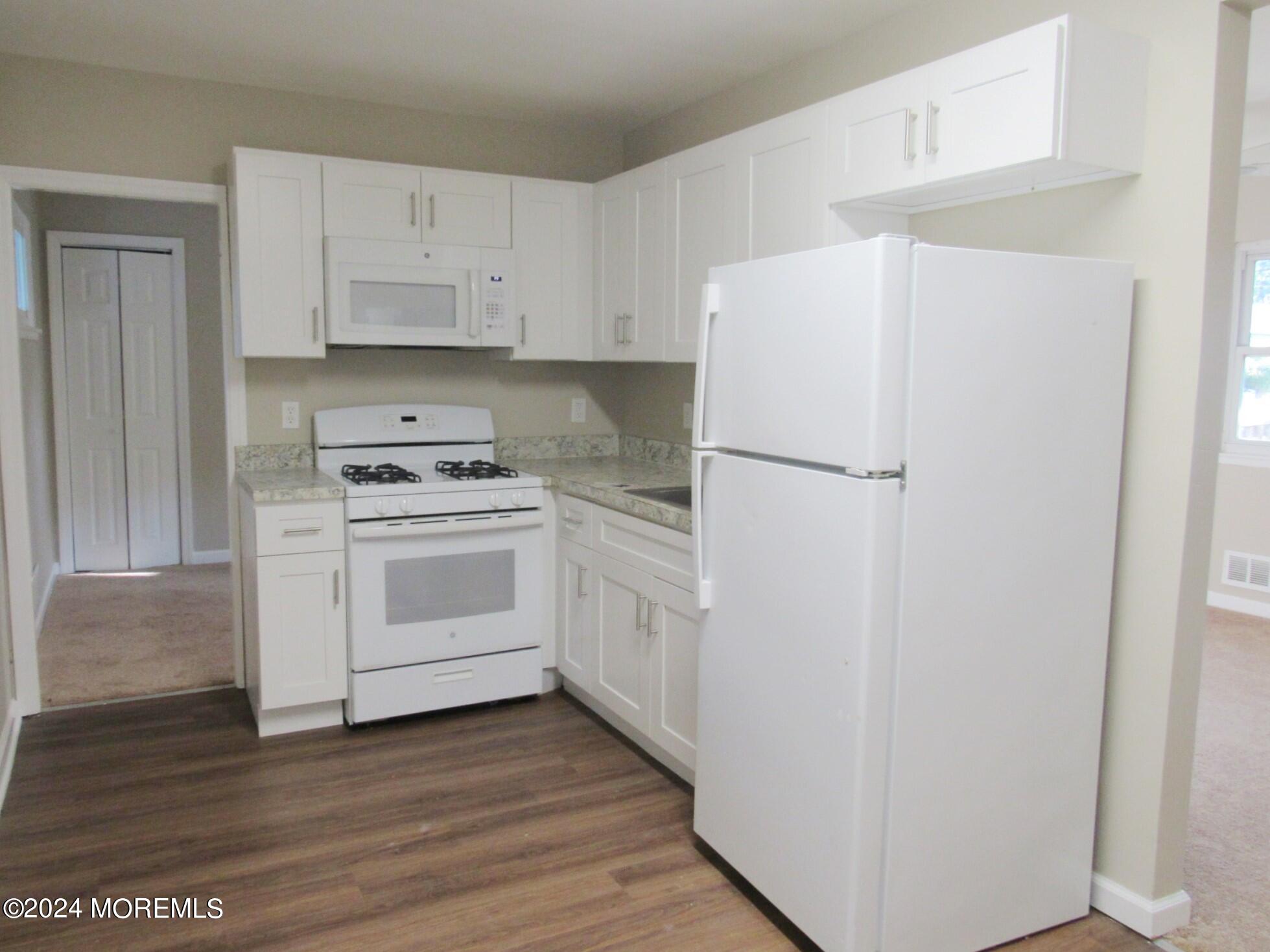 115 Solar Drive Brick, NJ 08724 - Photo 7 of 15 a white refrigerator freezer and a stove sitting inside of a kitchen with cabinets