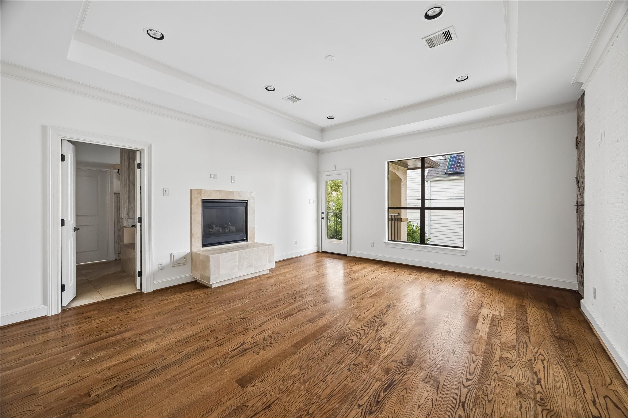 2246 Branard Street Houston, TX 77098 - Photo 23 of 40 Expansive primary suite with elevated tray ceilings, fireplace focal point, and private balcony access.